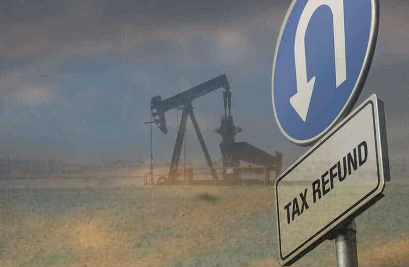Oil derrick and tax refund u-turn sign overlaid