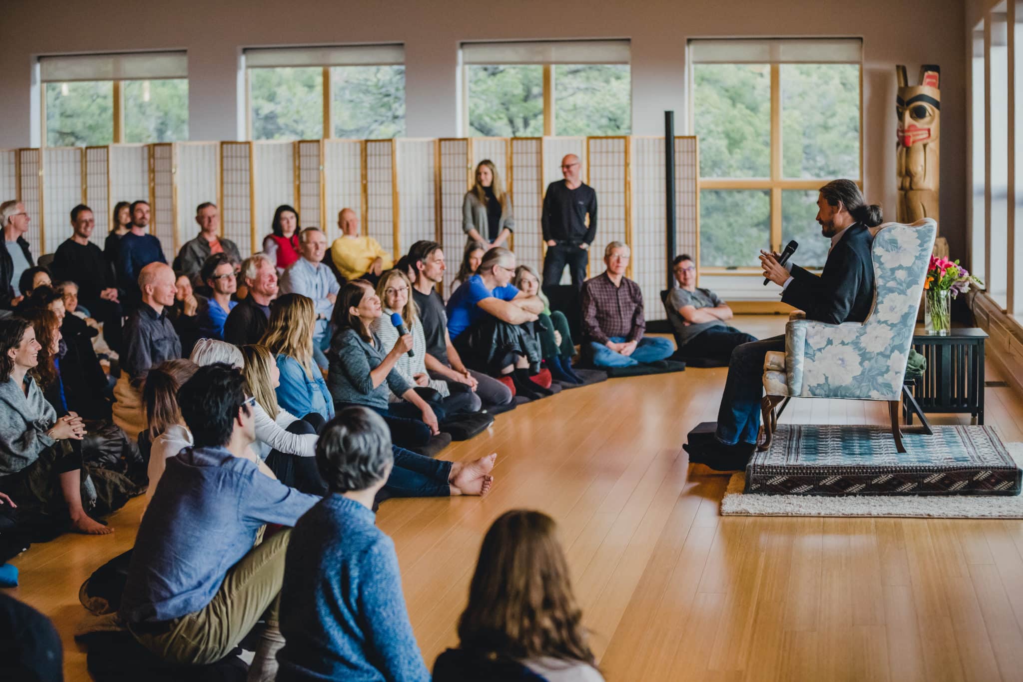 A group of people sitting on the floor listening to a talk