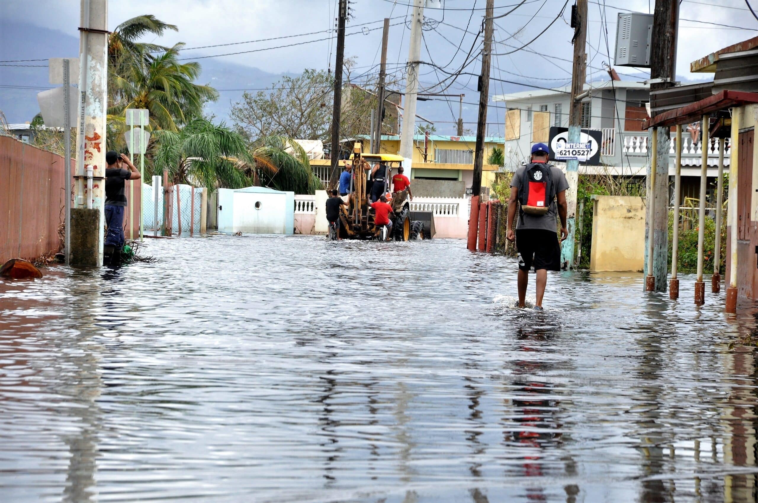 a person wades through floodwater on a street in Puerto Rico following Hurricane Maria in 2017