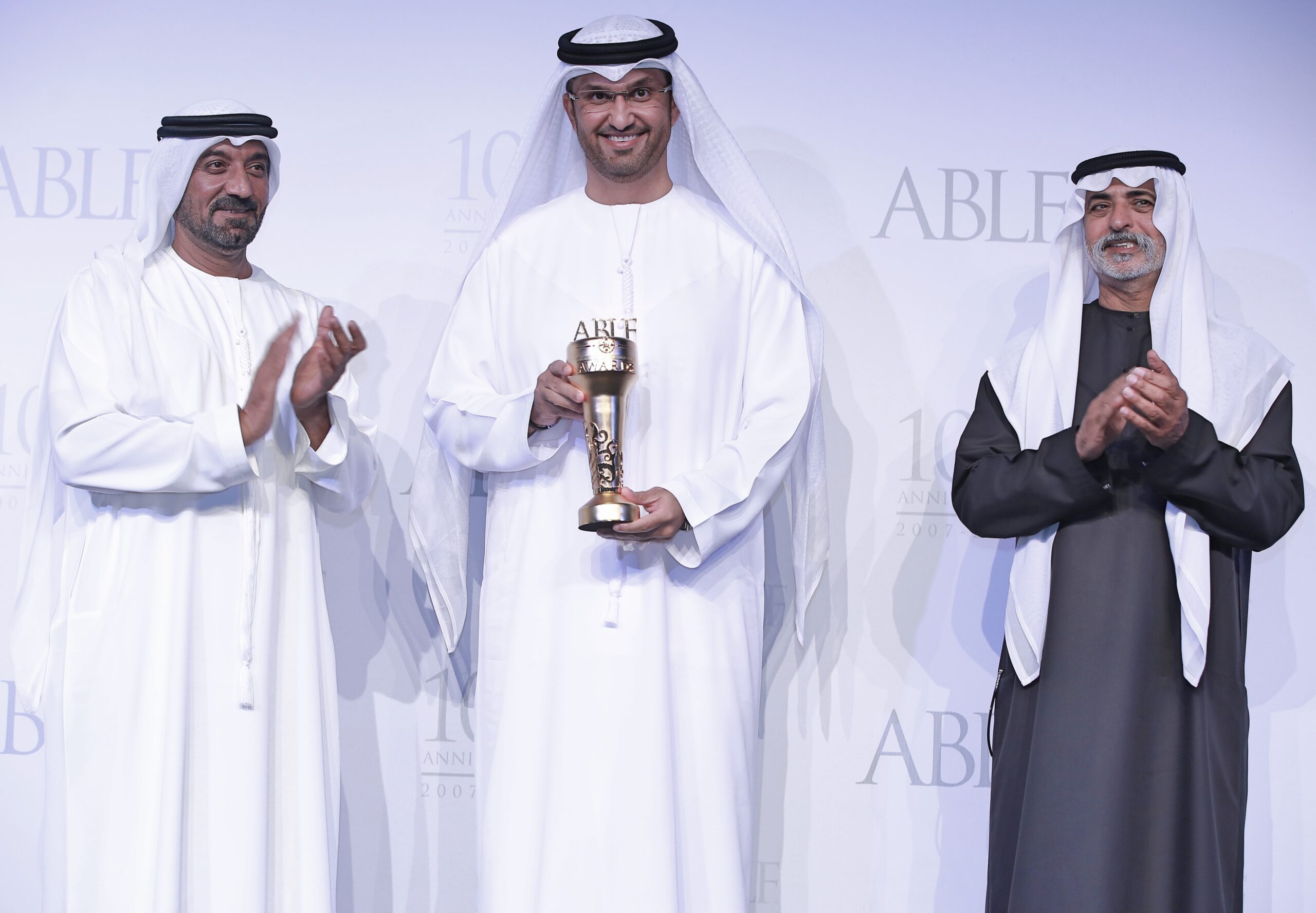 a photo of three men standing side by side at an award ceremony