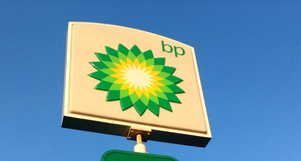 The sign, shown against a blue sky, shows BP's green and yellow flower logo.