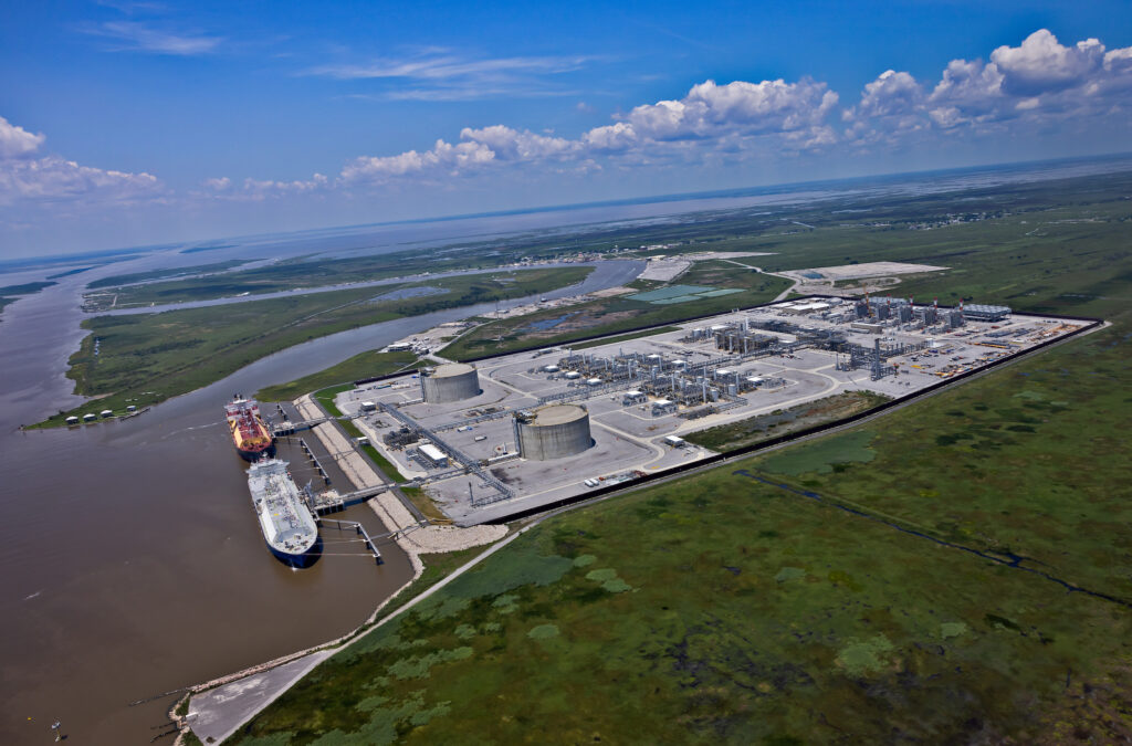 Two larg tankers being loaded at Venture Global's Calcasieu Pass LNG export terminal in Cameron, Louisiana, with a large green field in the foreground.