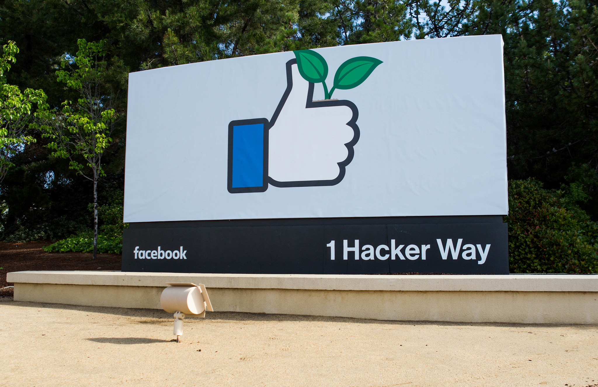 Sign with the thumbs-up 'like' icon with green leaves at the entrance to Facebook HQ in Menlo Park