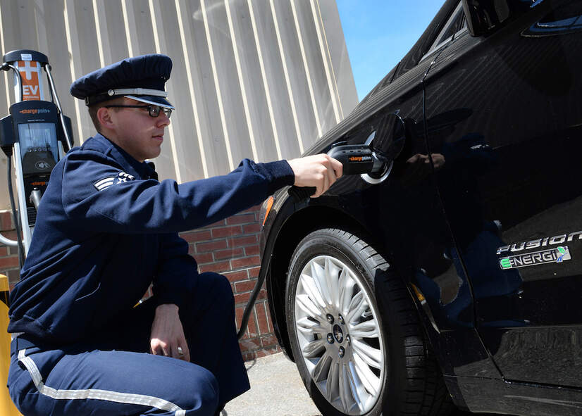 Senior Airman Alec Cope plugs in a hybrid vehicle at Hanscom Air Force Base, Massachusetts, June 2, 2016. The 66th Logistics Readiness Squadron unveiled the plug-in electric hybrid vehicle and charging station during an open house. 